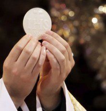 Priest holding up the eucharist